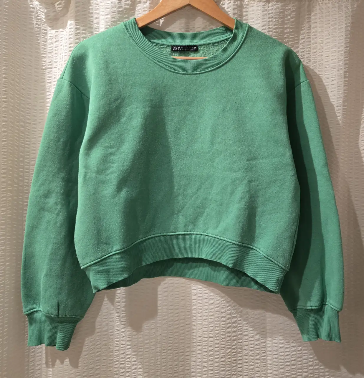 Buzo de cuello redondo verde. Ancho y corto