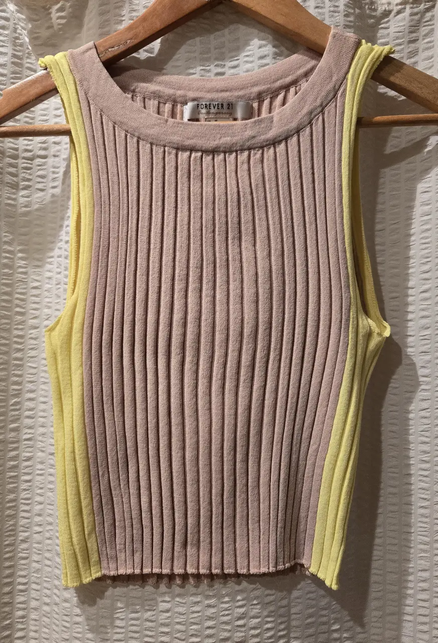 Musculosa de tejido de punto con diseño punto morley en color nude y detalle color lima en los laterales. 