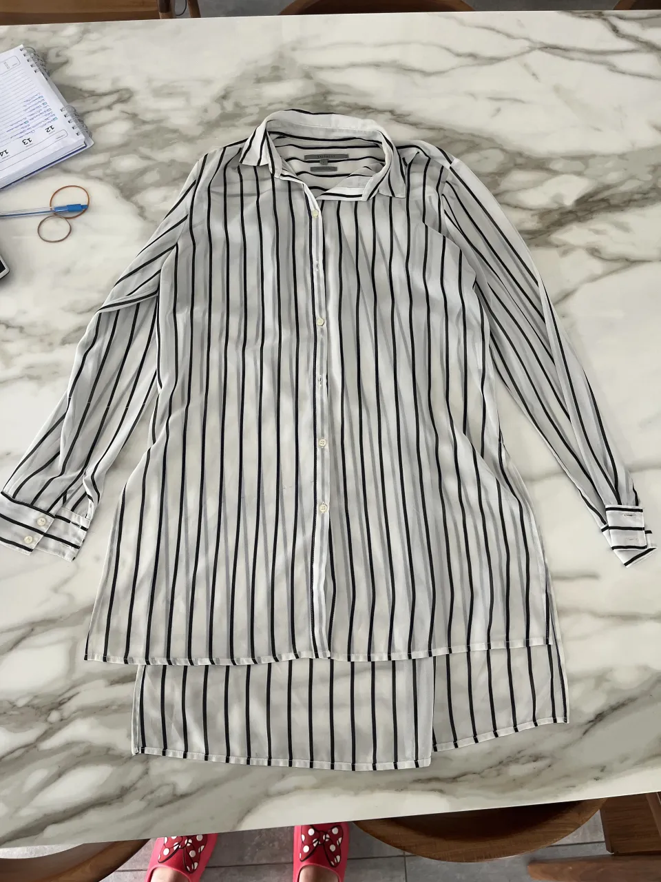 Camisa blanca con rayas verticales negras, manga larga y botones al frente. Un clásico que no puede faltar en tu guardarropa.