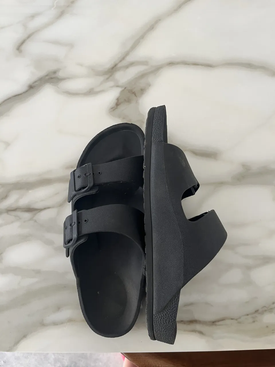 Ojotas negras de dos tiras con hebillas regulables. Ideales para el día a día, súper cómodas y versátiles. Perfectas para la playa, pileta o para estar en casa.