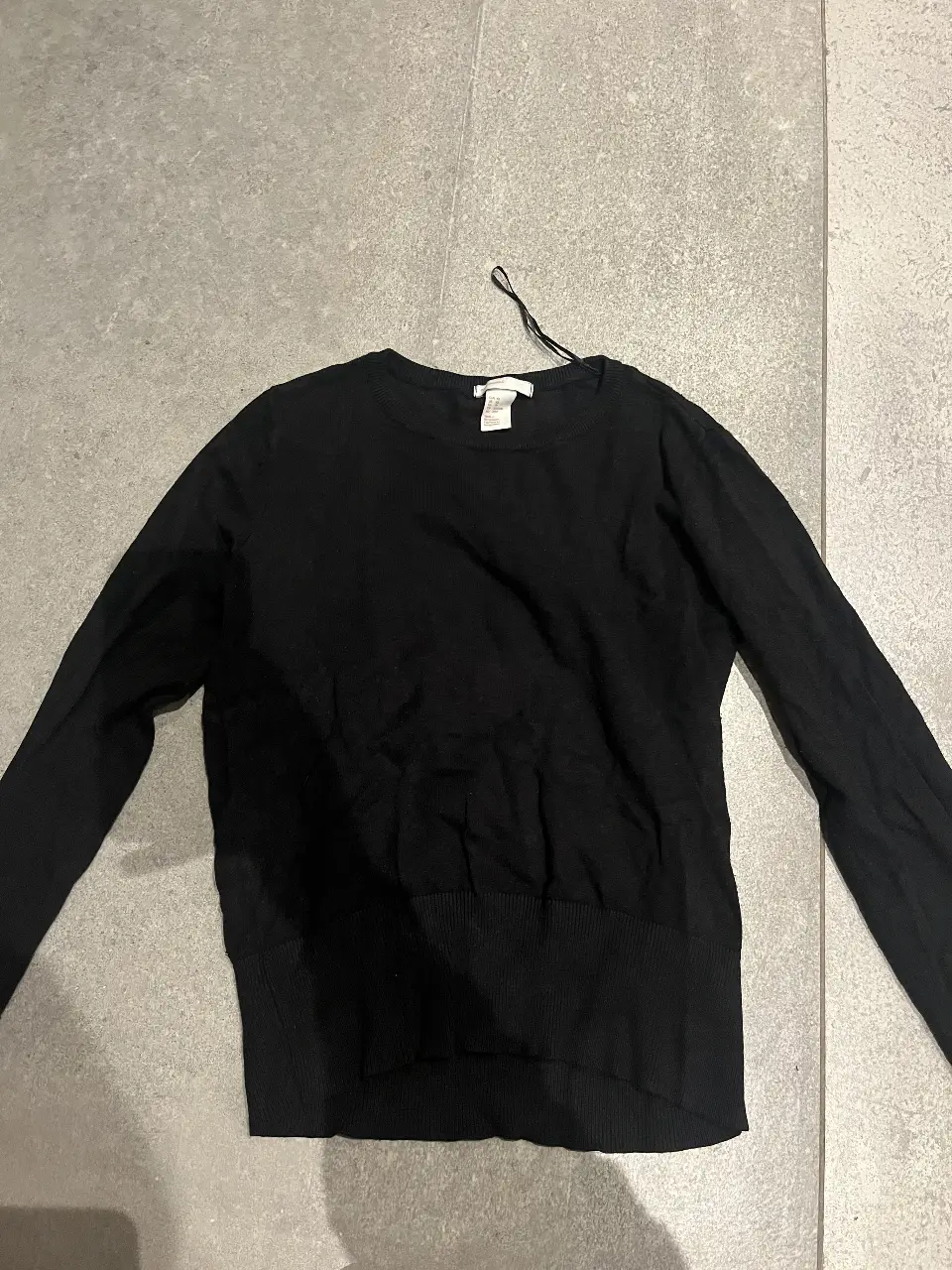 Sweater negro de tejido fino, ideal para un look casual y versátil. Perfecto para combinar con diferentes outfits.