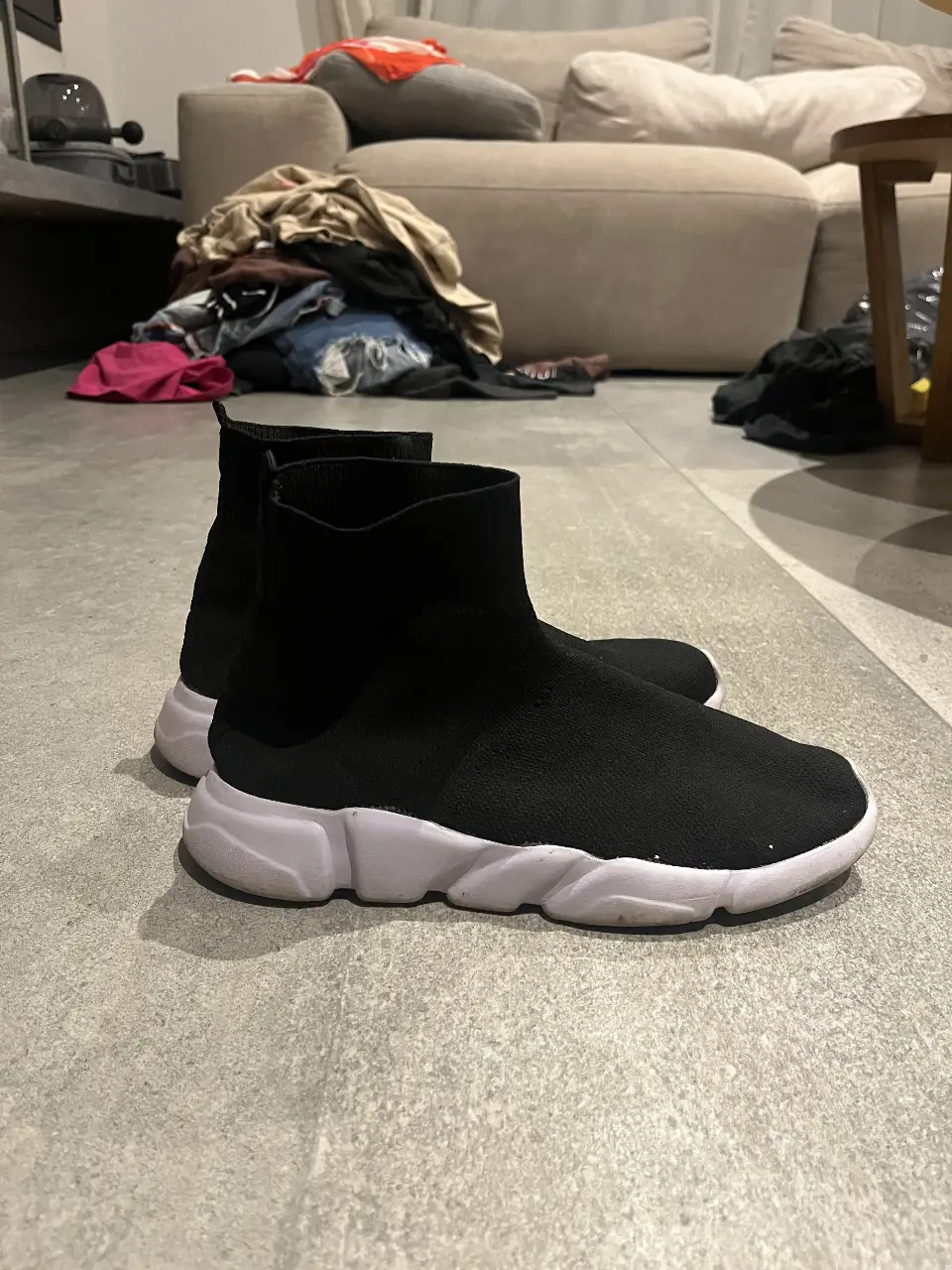 Zapatillas tipo botín de color negro con suela blanca. Ideales para un look moderno y urbano.