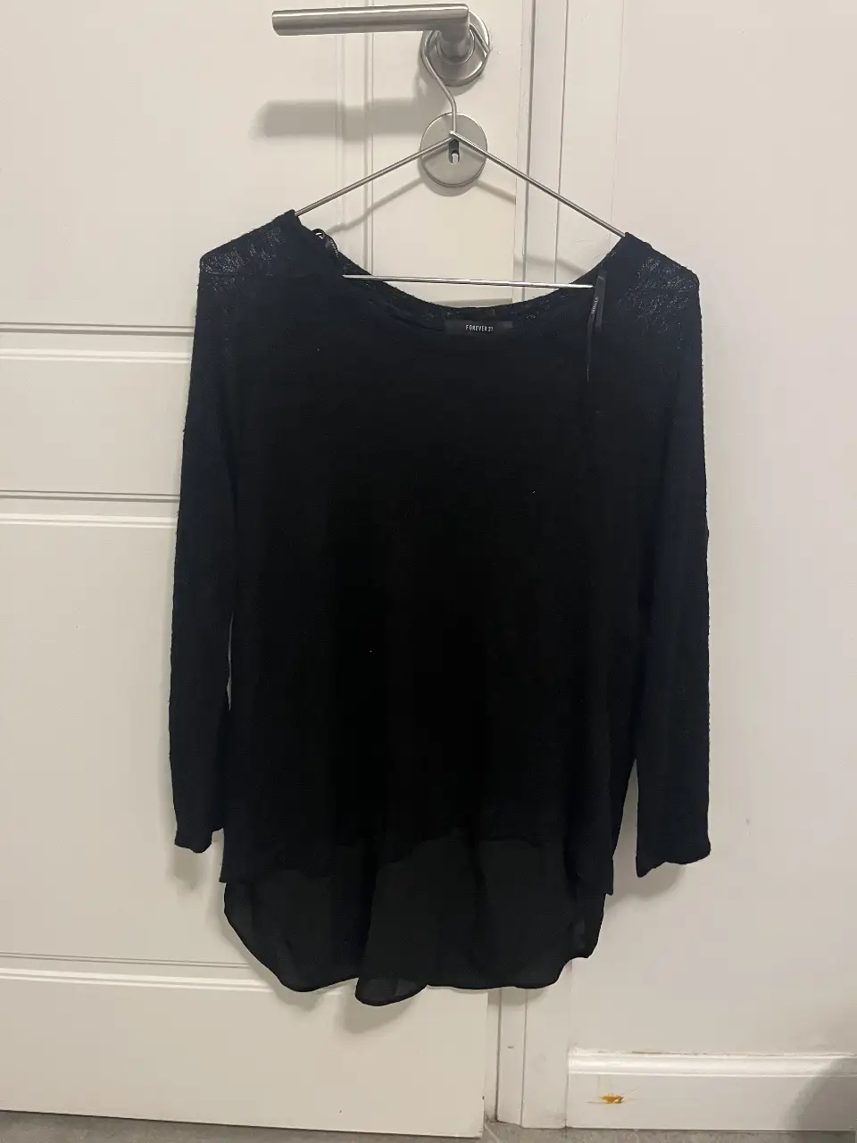 Blusa negra de Forever 21, con mangas largas y un diseño de dos capas. Ideal para un look casual o para salir.