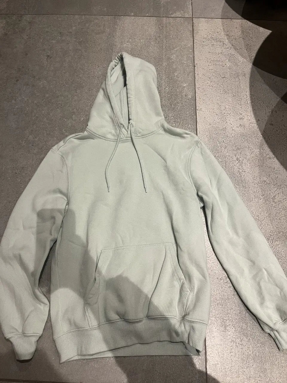 Buzo canguro de hombre, color verde claro, de la marca H&M. Talle XS. Corte relajado, ideal para un look casual y cómodo.