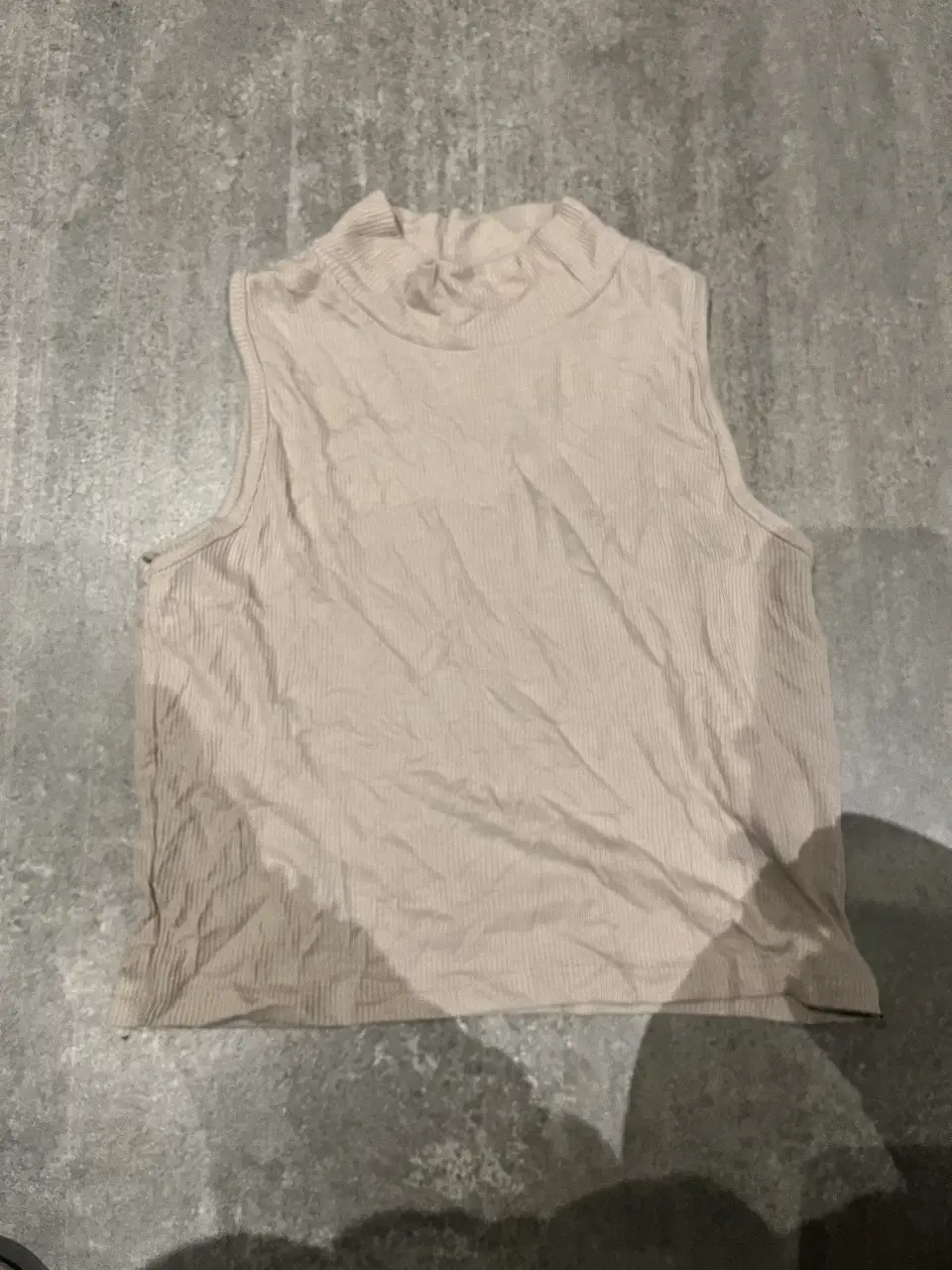 Top tejido de cuello alto, sin mangas, ideal para un look casual y moderno. Perfecto para combinar con jeans o pantalones de vestir.