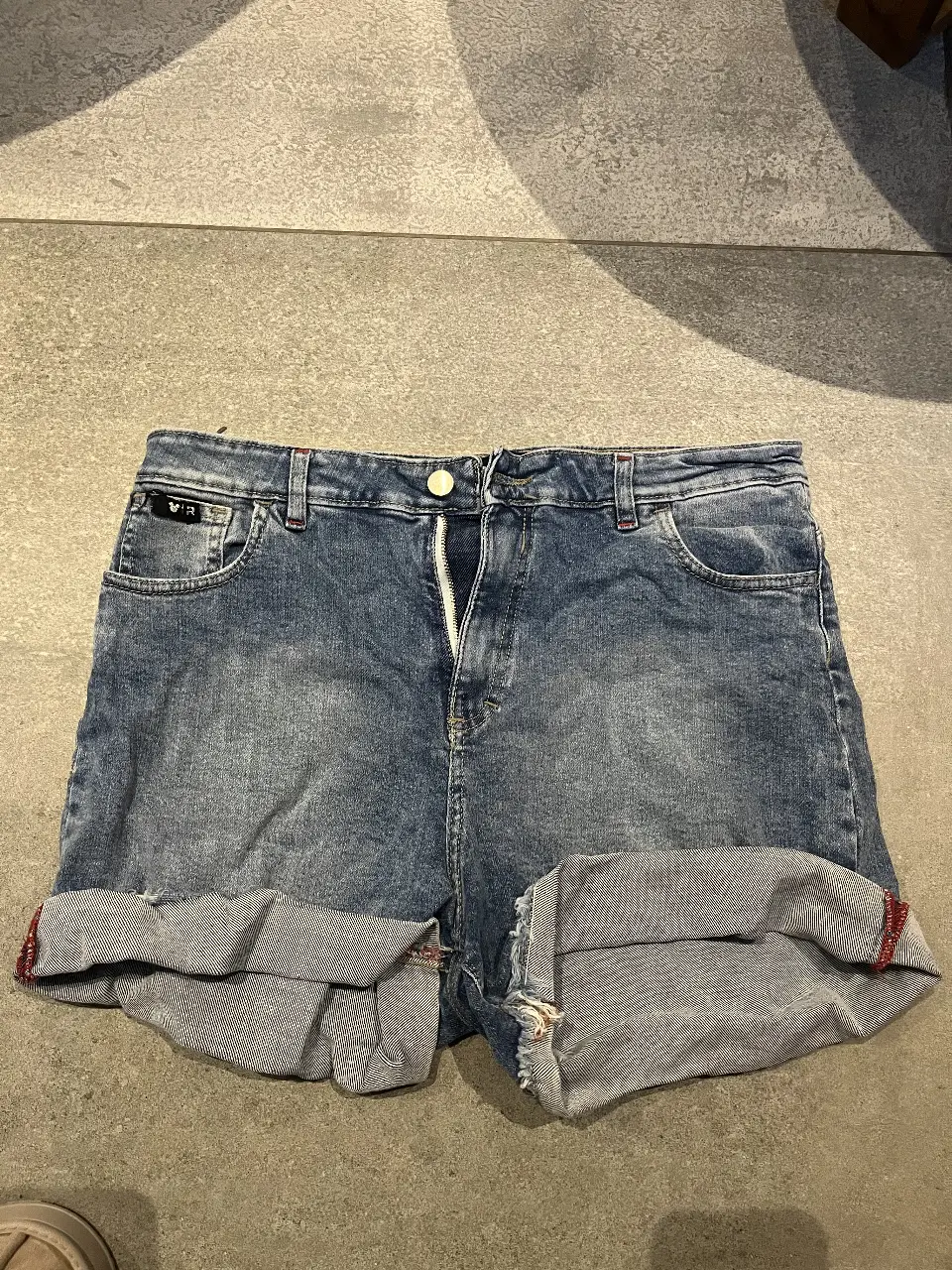 Short de jean azul con dobladillo. Talle 28. Ideal para un look casual y cómodo.