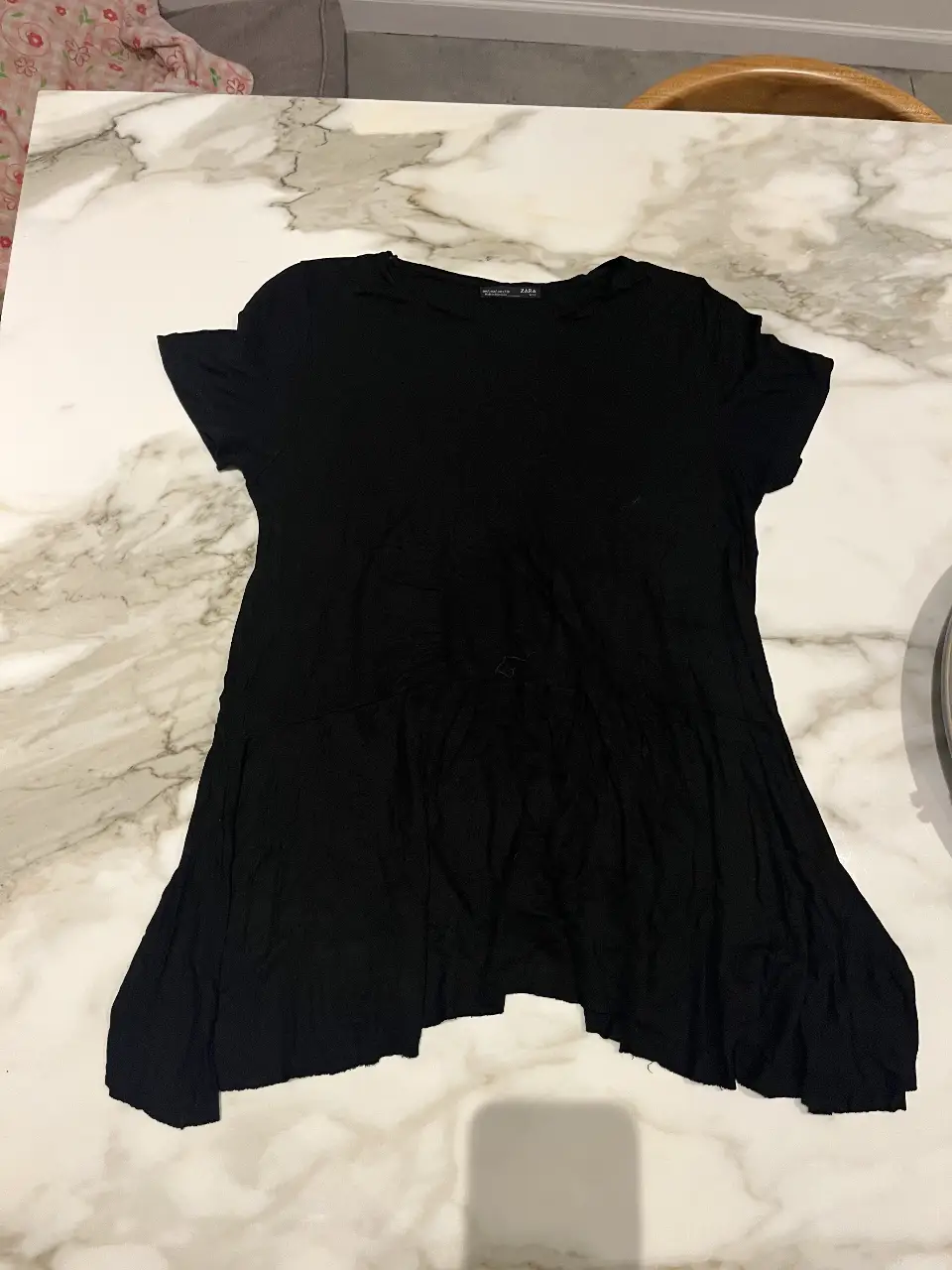 Vestido negro corto de Zara, con corte en la cintura y mangas cortas. Ideal para un look casual y cómodo.