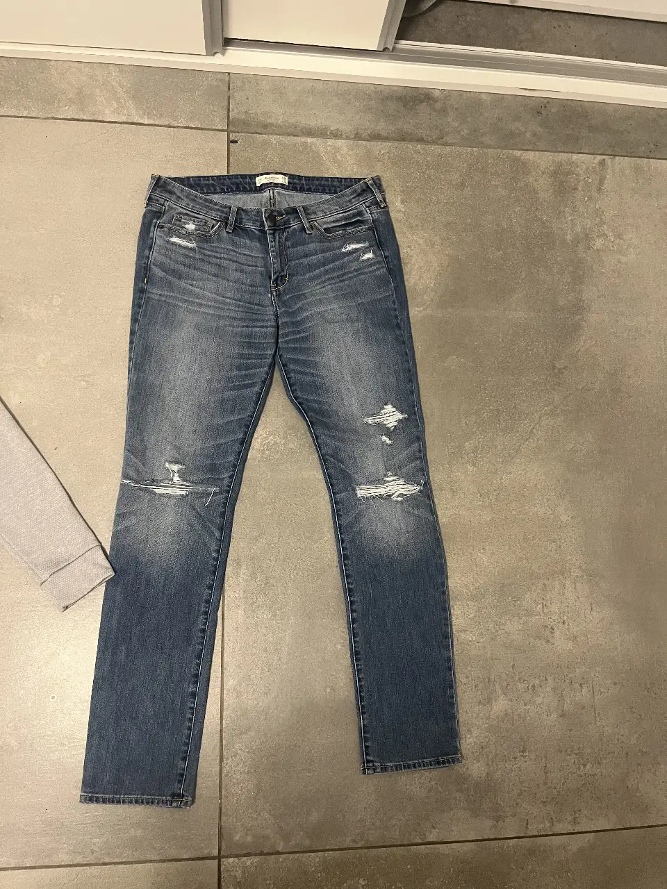 Jeans rectos de hombre, con roturas en las rodillas. Talle 30, de la marca Abercrombie & Fitch. Ideal para un look casual y moderno.