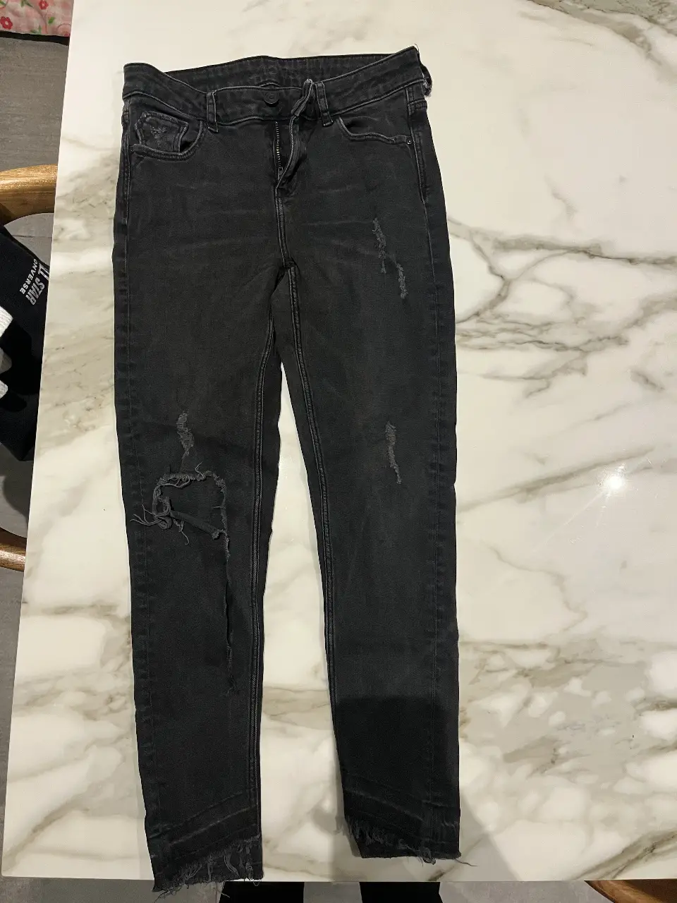 Jeans de mujer negros con roturas en las rodillas, tiro medio y corte skinny. Marca Zara Basic, talle 36.
