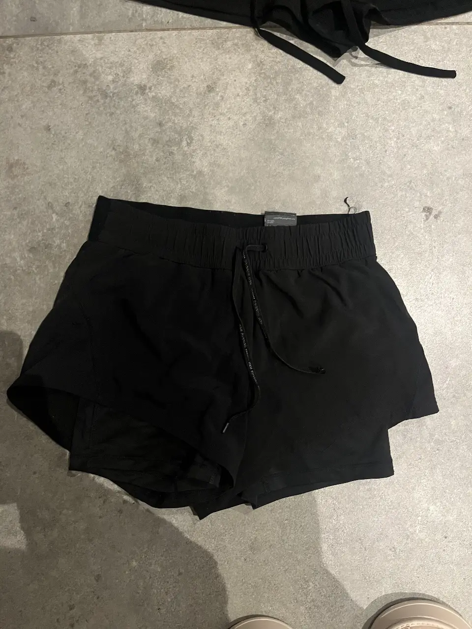 Short deportivo negro con cintura elastizada y cordón ajustable. Ideal para actividades físicas.