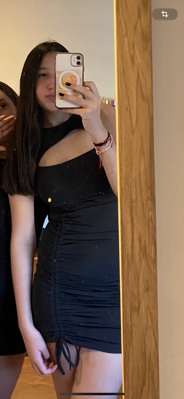Vestido negro mini con un corte asimétrico en el pecho y fruncido en la parte inferior. Ideal para una salida nocturna.