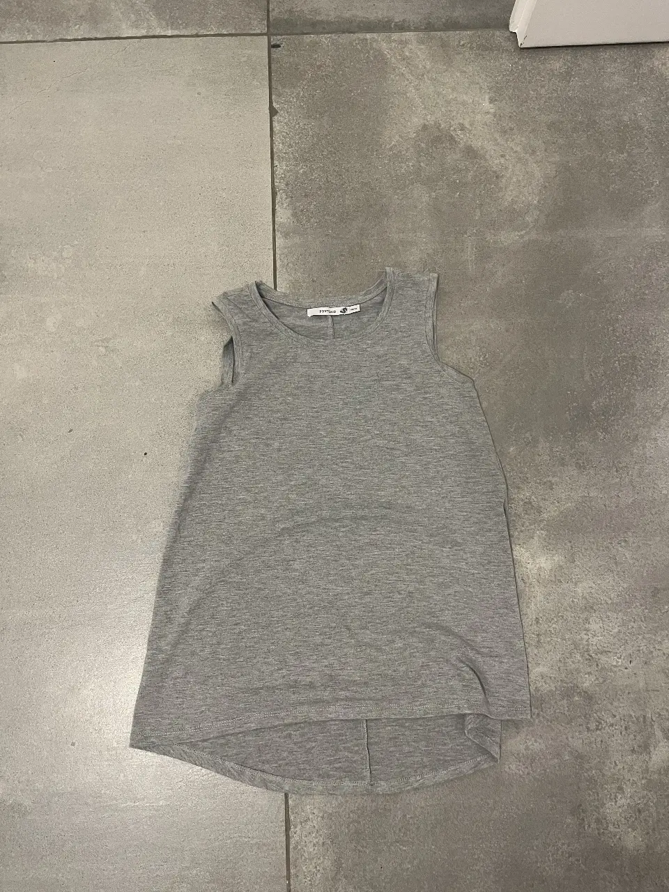 Musculosa gris de mujer, ideal para el verano. Confeccionada en tela suave y cómoda, perfecta para un look casual y fresco.