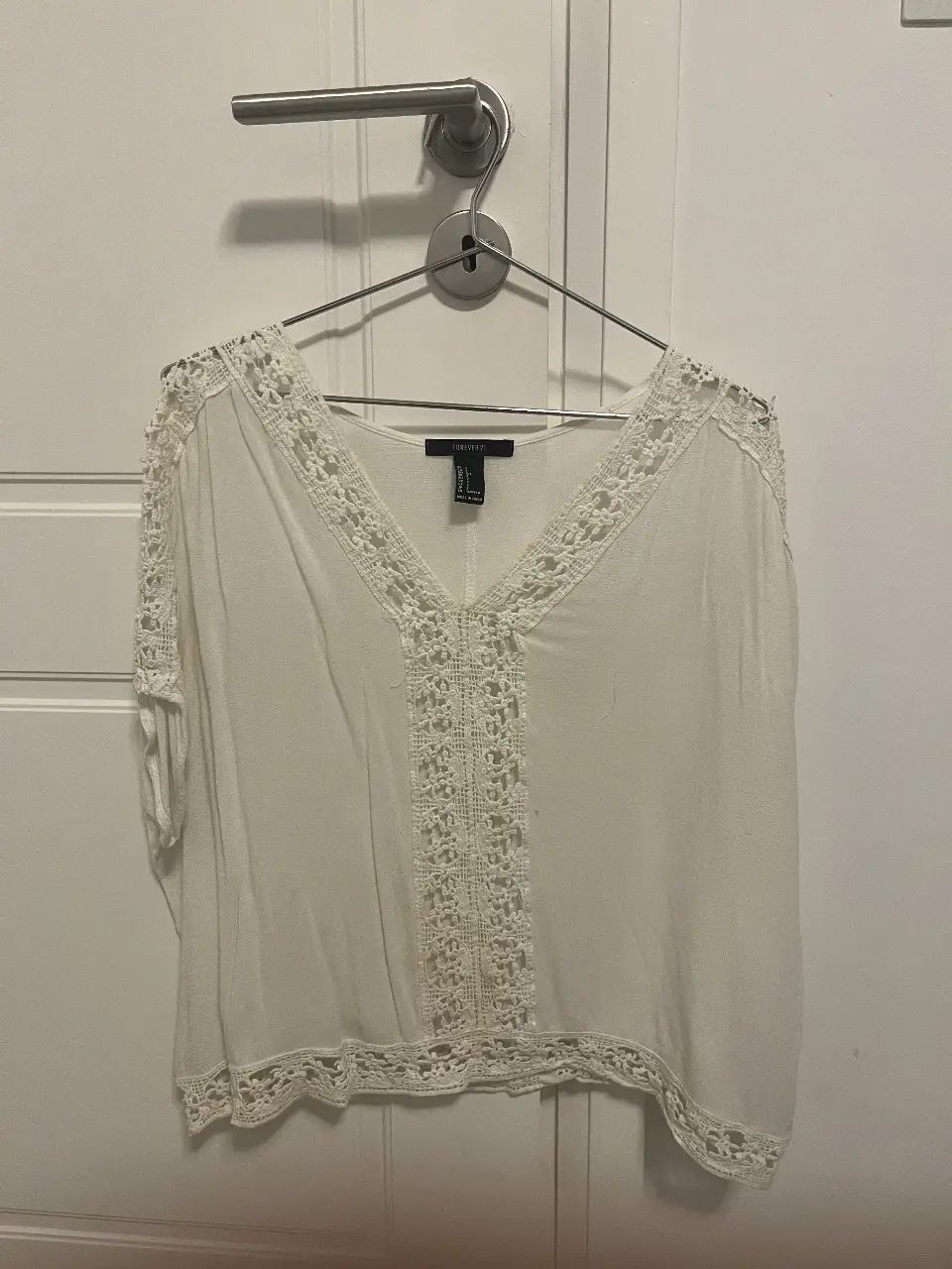 Blusa blanca de Forever 21 con detalles de encaje. Ideal para un look casual y fresco.