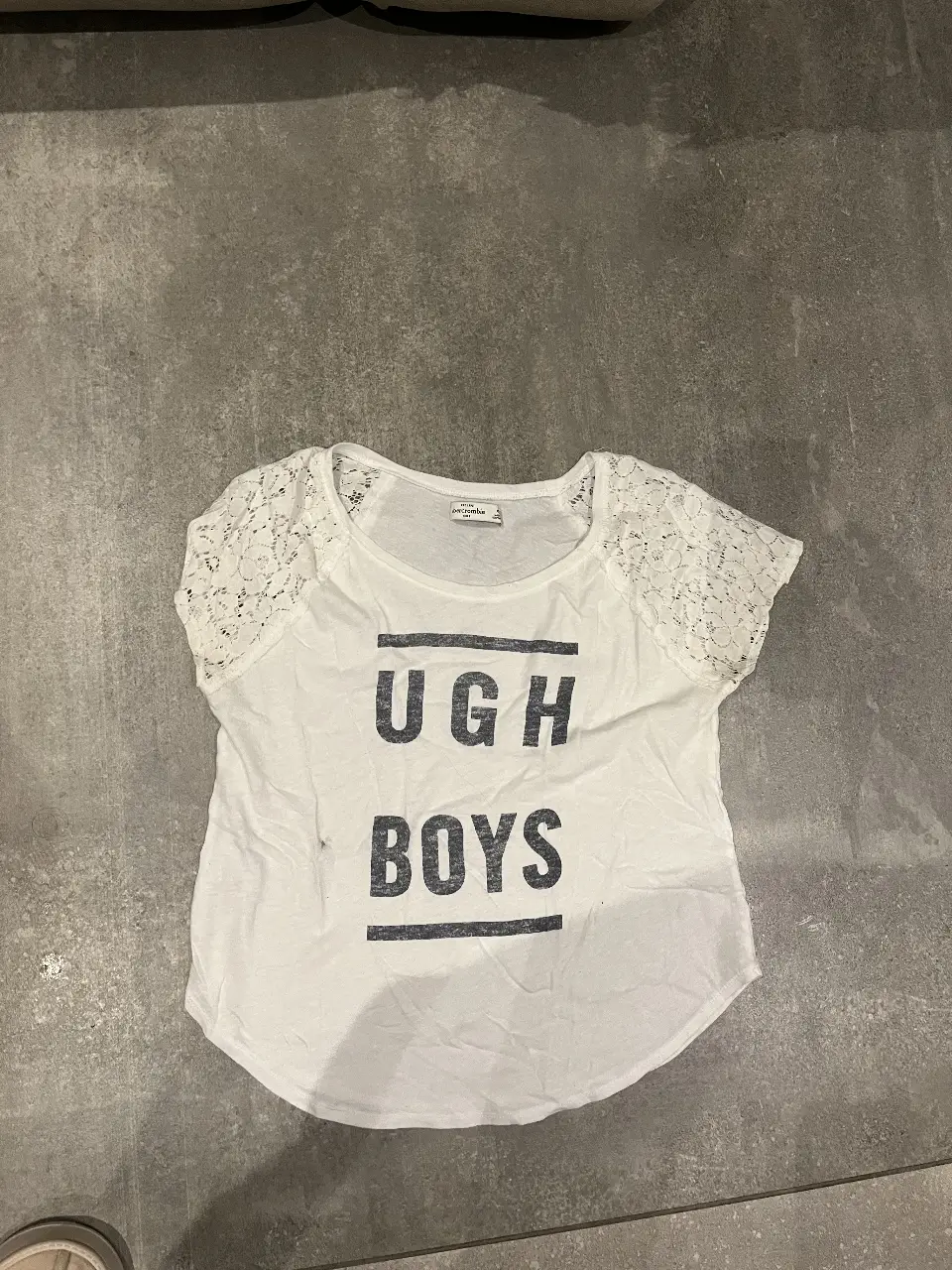 Remera blanca de algodón con estampado "UGH BOYS" y detalles de encaje en las mangas. Talle XL de Abercrombie.