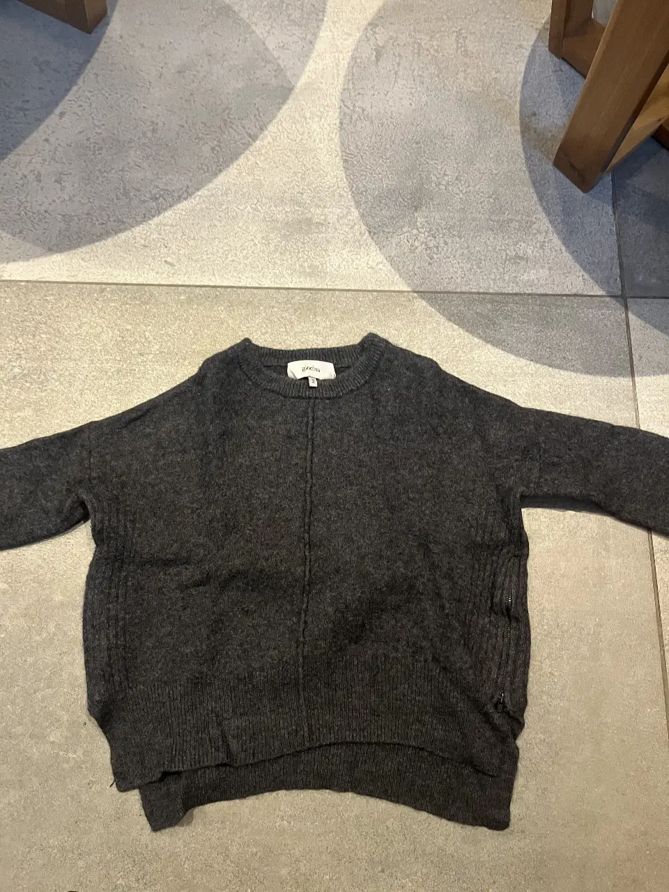 Sweater de mujer de color gris oscuro, con cuello redondo y detalle de costura central. Ideal para un look casual y abrigado.