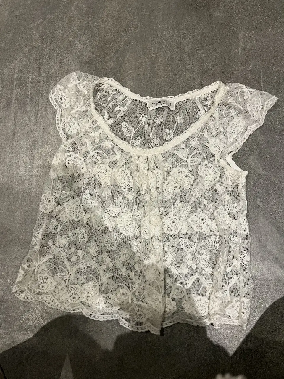 Blusa de encaje blanca, ideal para un look romántico y delicado. Perfecta para combinar con jeans o faldas.