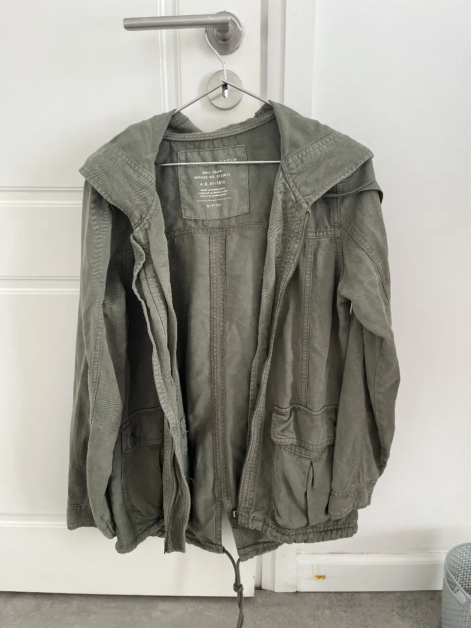 Campera verde militar de American Eagle, con capucha y bolsillos. Ideal para un look casual y cómodo.