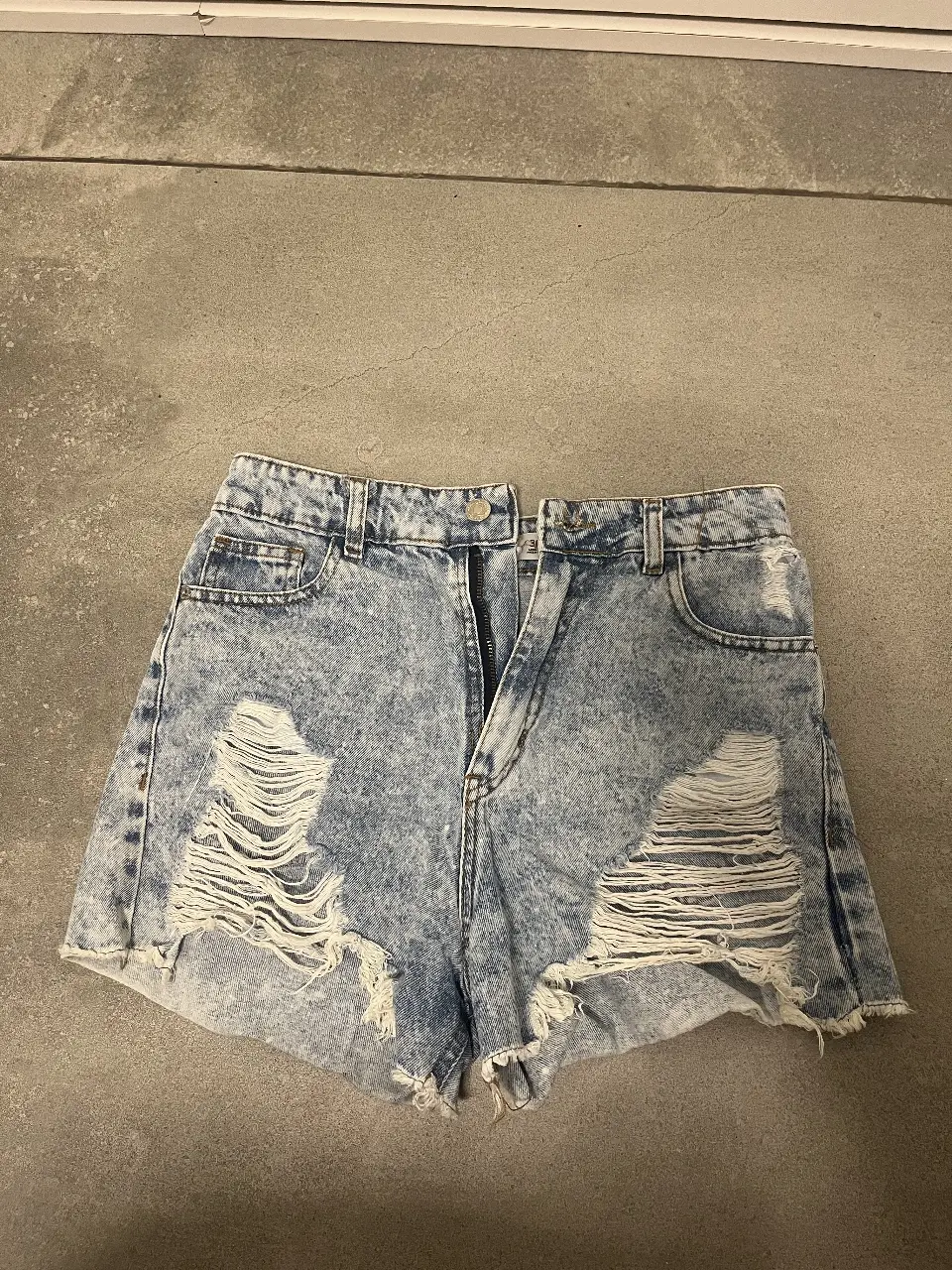 Short de jean de mujer, tiro alto, con roturas en la parte delantera. Talle 36, de la marca Osaina Denim. Ideal para un look casual y moderno.