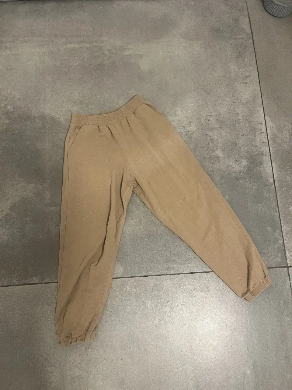 Pantalón de jogging suelto color crudo, con cintura elastizada y puños en los tobillos. Ideal para un look cómodo y casual.