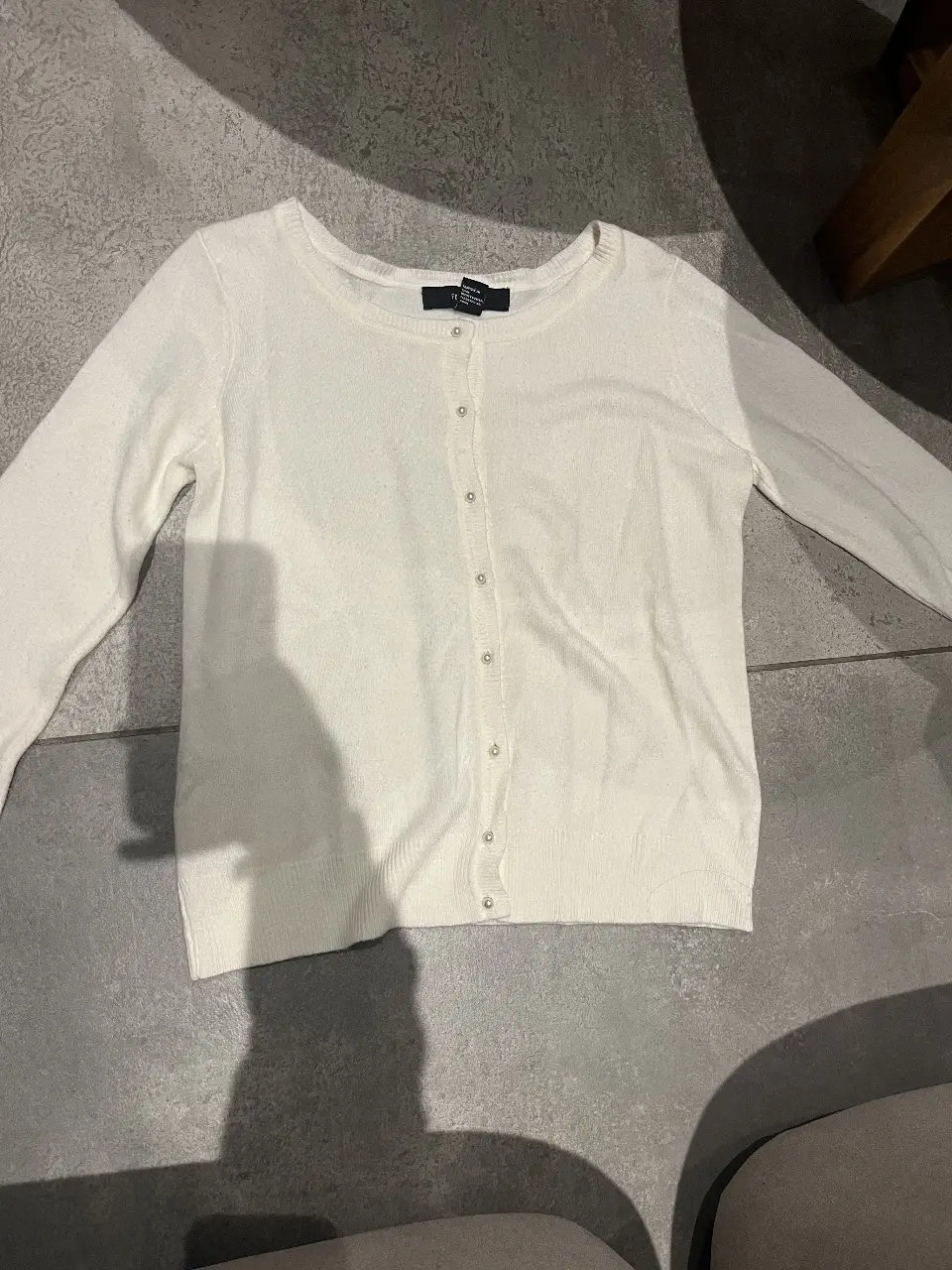 Cardigan blanco de Forever 21, con botones y mangas largas. Ideal para un look casual y versátil.