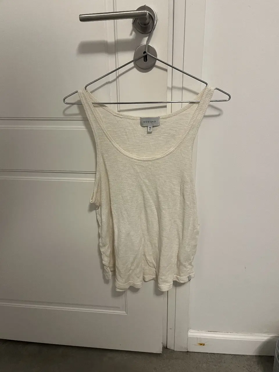 Musculosa de mujer, de color blanco, con cuello redondo y corte holgado. Ideal para un look casual y fresco.