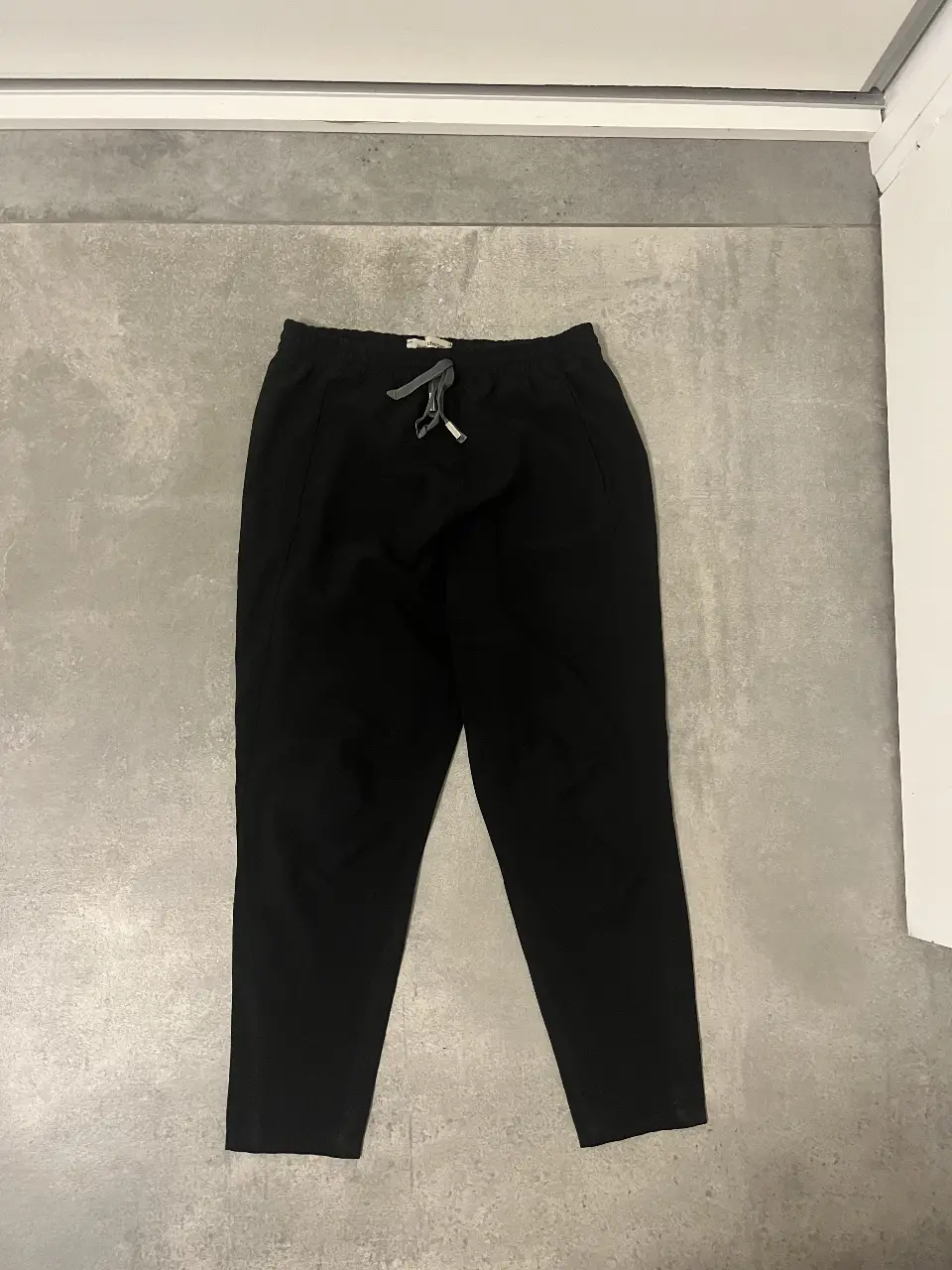 Pantalón de vestir negro de la marca Jazmin Chebar, con cintura elastizada y cordón ajustable. Ideal para un look elegante y cómodo.