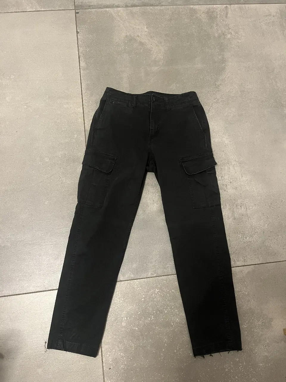 Pantalón cargo negro, ideal para un look utilitario y casual. Confeccionado en tela resistente, este pantalón ofrece múltiples bolsillos y un corte recto.