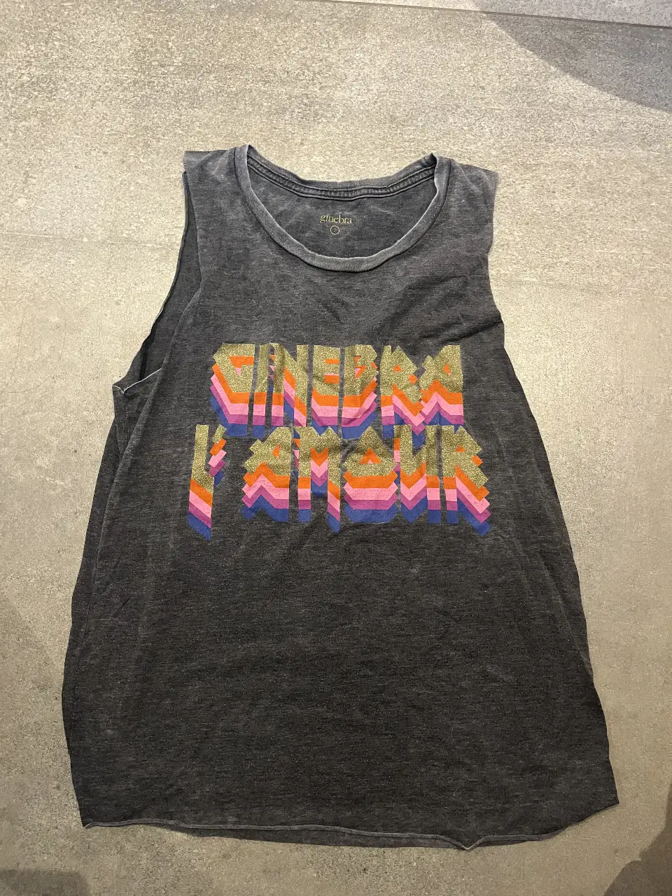 Musculosa de mujer con estampado "Ginebra L’ amour". Diseño retro con letras en colores vibrantes. Ideal para un look casual y con onda.