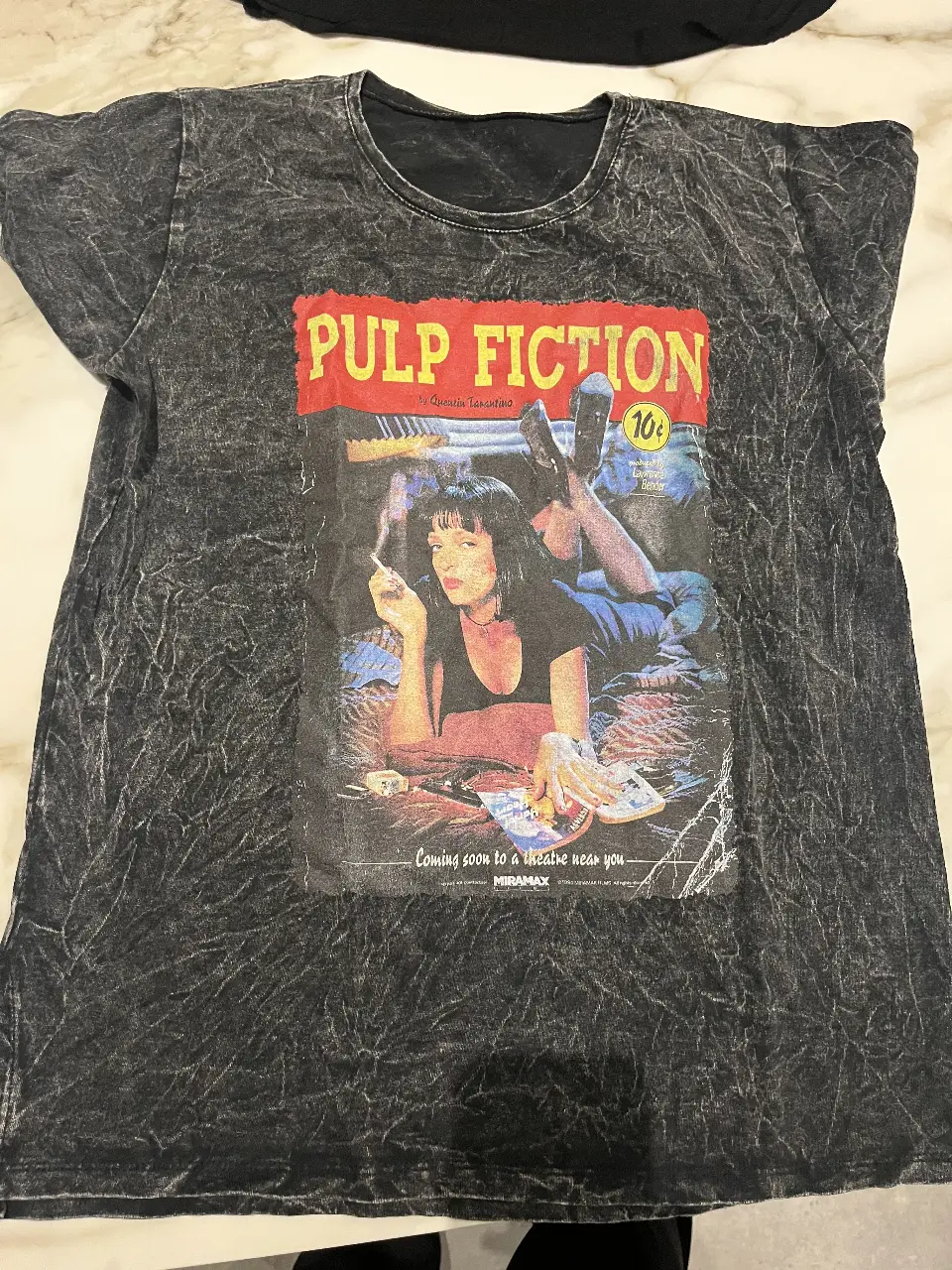 Remera de algodón con estampado de la película Pulp Fiction. Diseño vintage con la imagen icónica de Mia Wallace. Ideal para un look casual y retro.