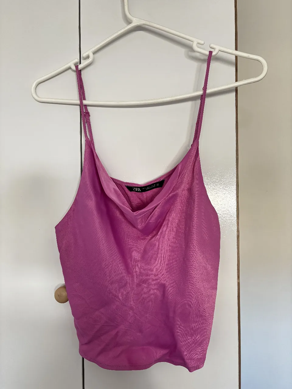 Top de satén color rosa Dior con cuello drapeado y tirantes finos. Ideal para una salida o evento especial. Marca Zara hecha en Turquía. 