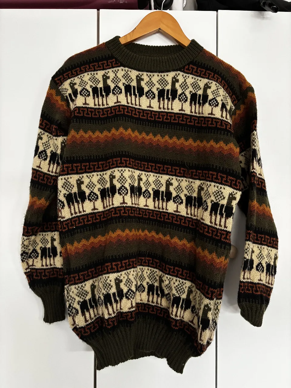 Sweater tejido con diseño de llamas y árboles en tonos tierra y verde. Ideal para un look vintage y abrigado.