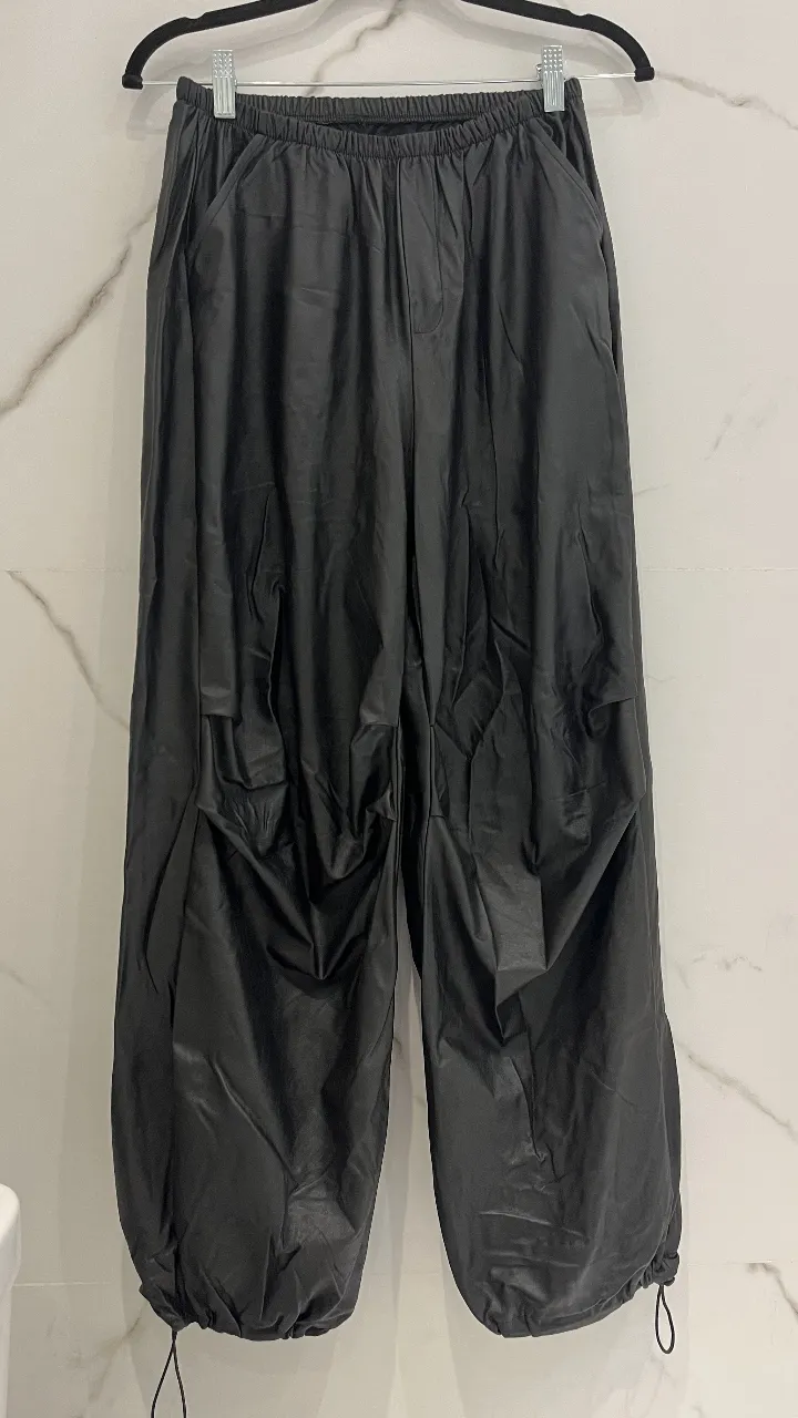 Pantalón cargo de cuero sintético suelto de mujer, negro, con ajuste en los tobillos. Ideal para un look canchero y cómodo.