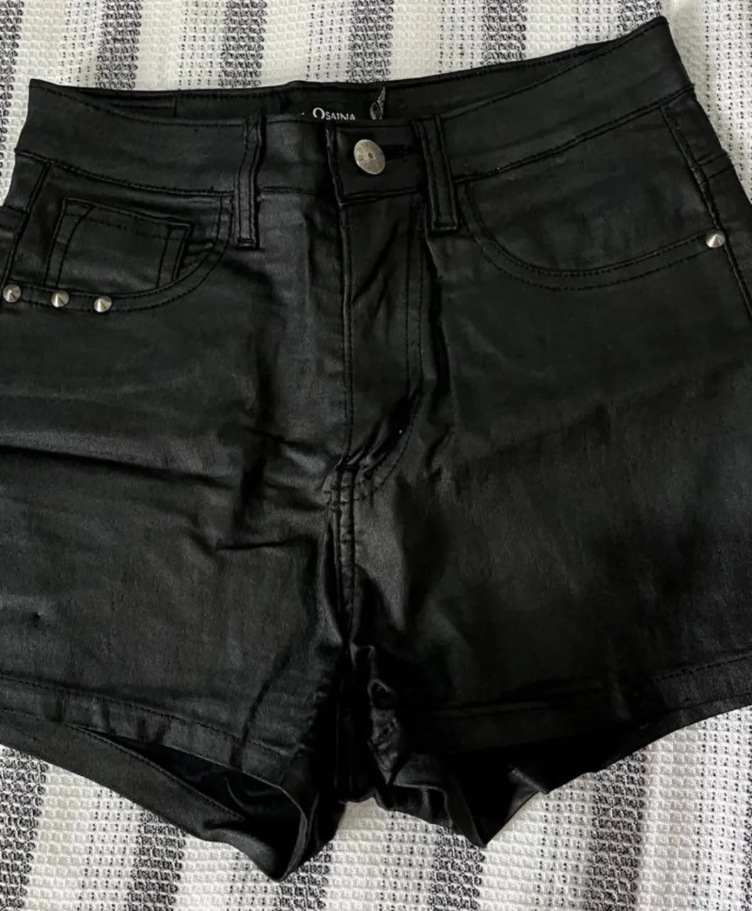 Short de jean negro de mujer, tiro alto, con detalles de tachas en los bolsillos. Marca Osaina, talle 38.