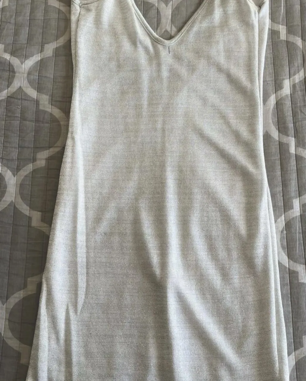 Vestido mini gris con brillos y escote en V, ideal para una salida. Con forro interior para mayor comodidad.