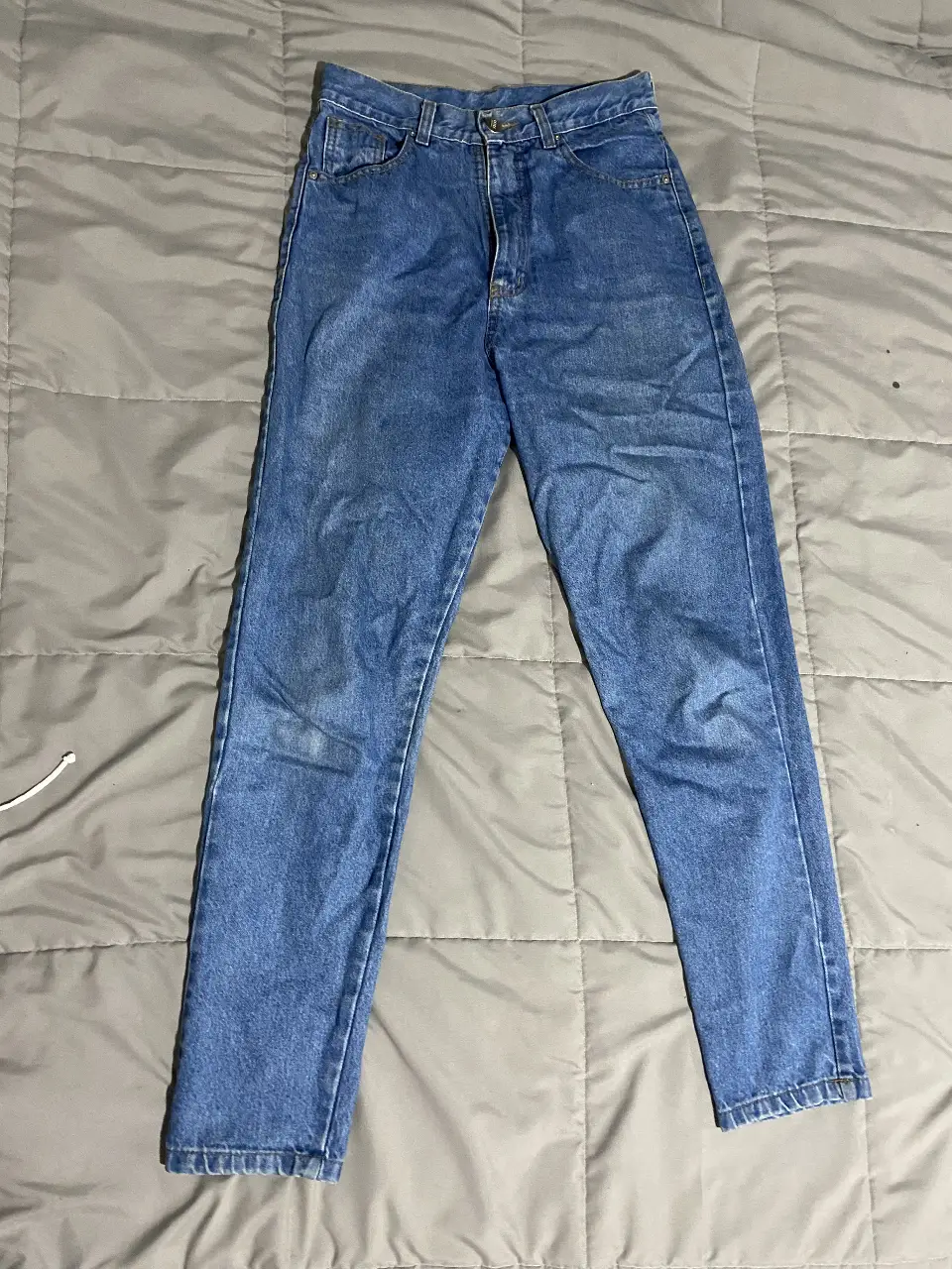 Jeans rectos de denim azul, tiro medio, ideales para un look casual y versátil. Un clásico que no puede faltar en tu guardarropa.