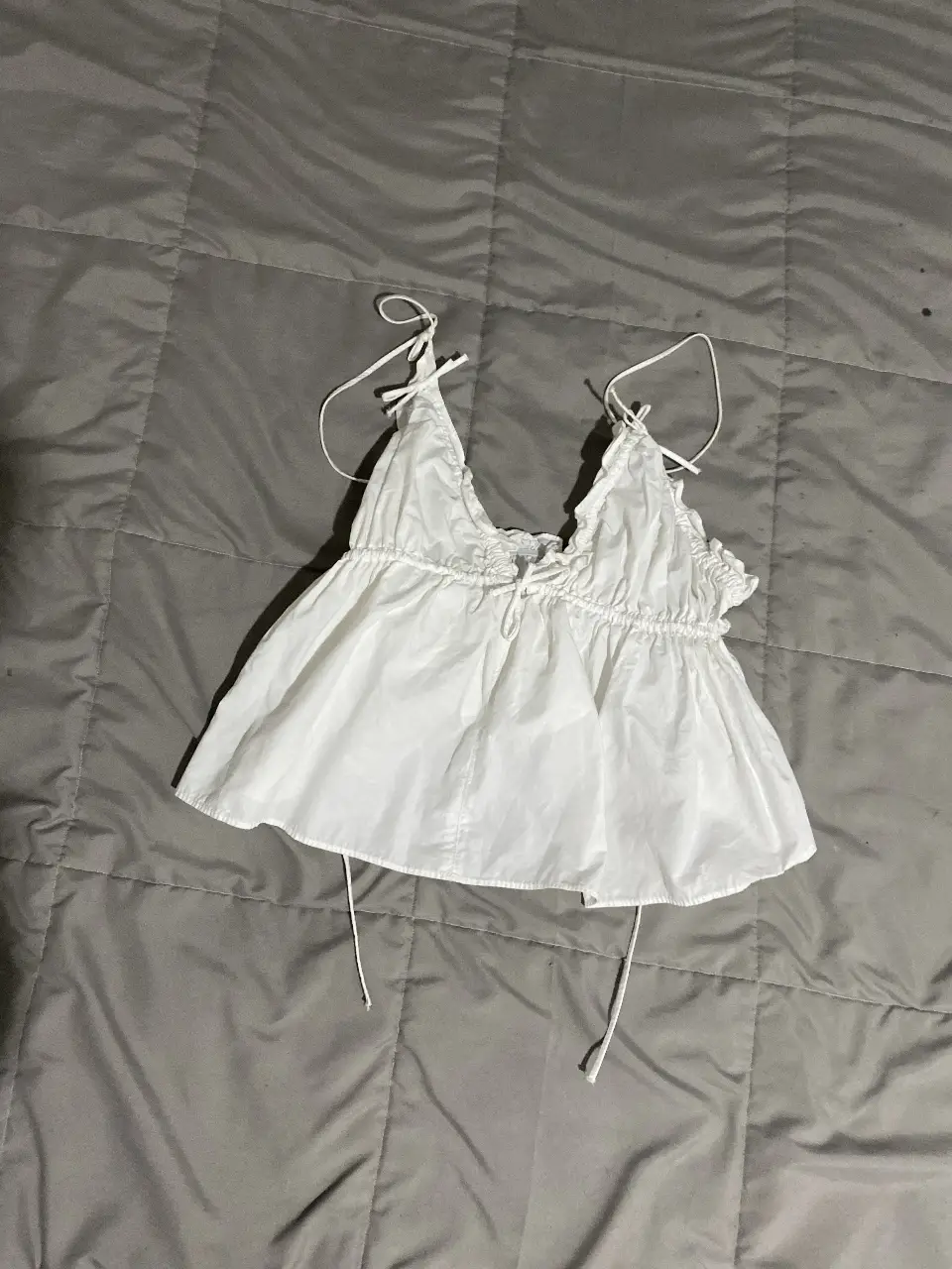 Top blanco con tiras ajustables y detalle de volados. Ideal para un look fresco y casual.