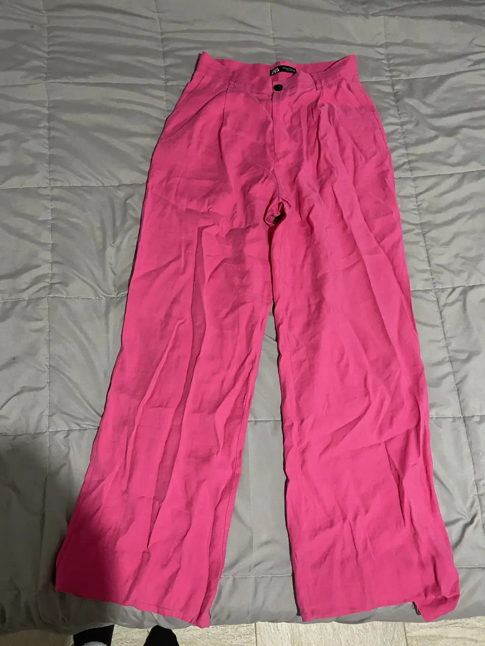Pantalón sastrero de mujer, color rosa chicle. Tiro alto, con pinzas delanteras y cierre con botón. Amplio y cómodo, ideal para un look moderno y elegante.