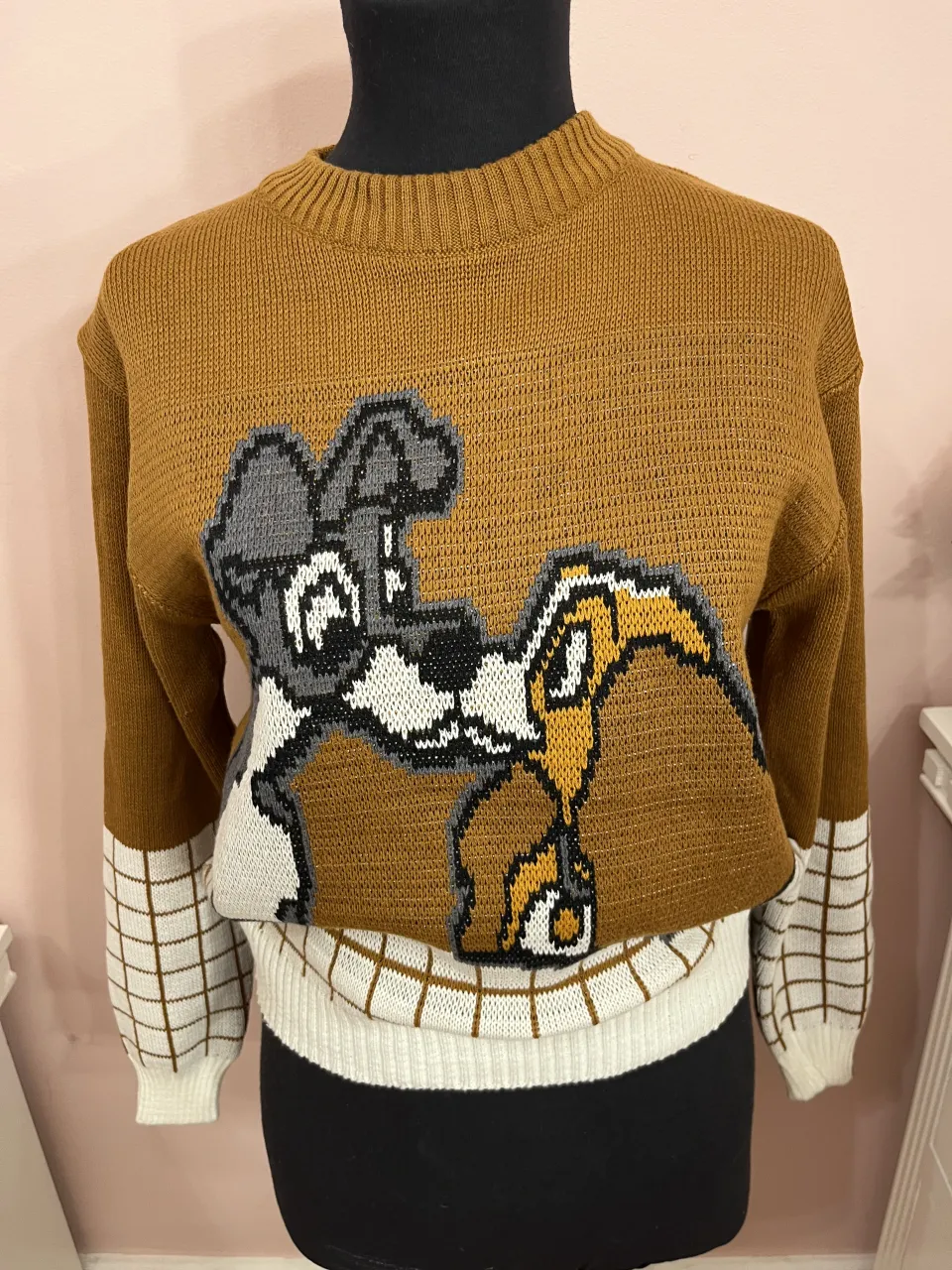 Sweater La dama y el Vagabundo. Las mangas tienen un diseño de cuadros blancos y marrones. Cuello redondo y puños de ribb. Nuevo sin uso.