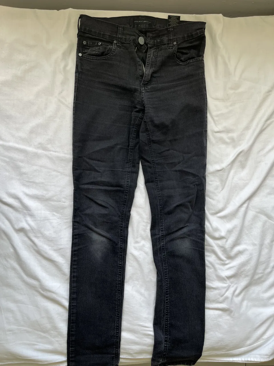Jeans negros tiro alto, corte recto y ajustado. Perfectos para un look casual y moderno, ideales para combinar con cualquier tipo de calzado y prenda superior. Su diseño versátil los hace un básico indispensable en tu guardarropa.
