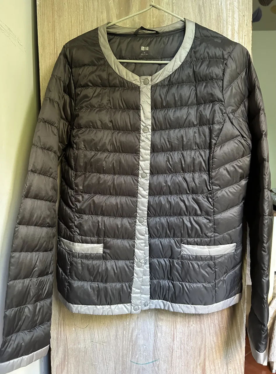 Campera de pluma Uniqlo, color gris oscuro con detalles en gris claro. Talle M. Ideal para el invierno, abrigada y liviana.
