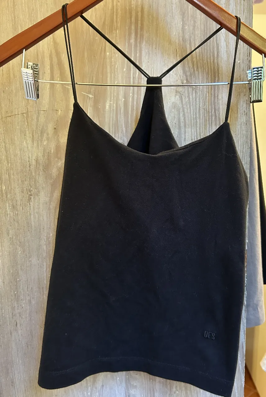 Top negro de mujer, con espalda cruzada y breteles finos. Ideal para un look casual y moderno.