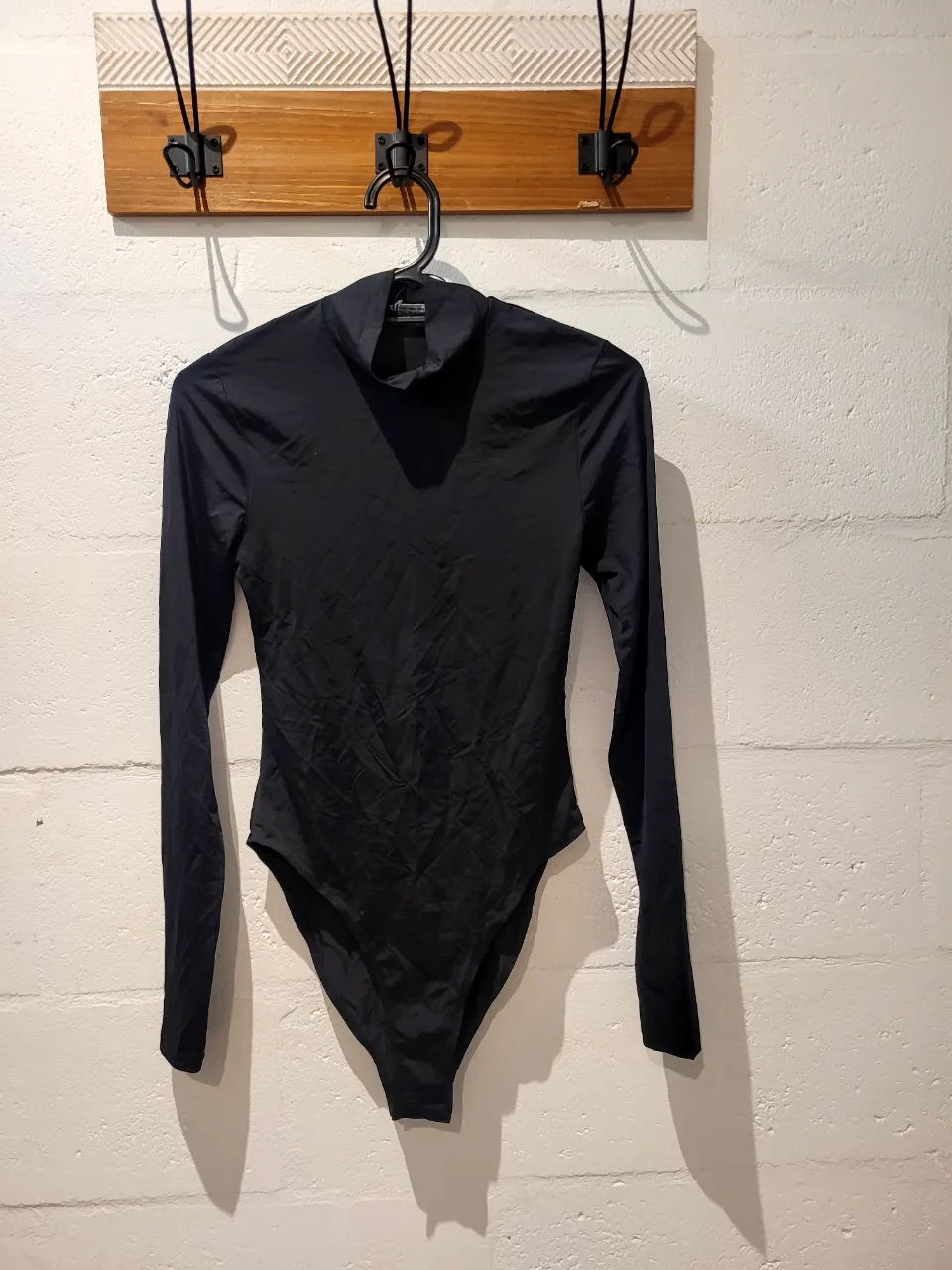 Body negro de manga larga y cuello alto.