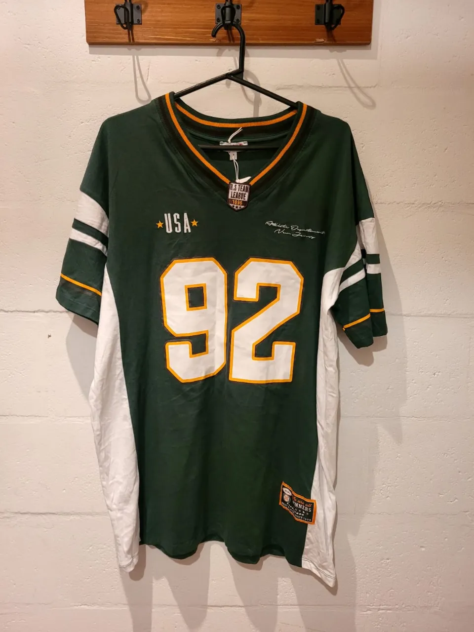 Remera deportiva oversize estilo "football" con el número 92 y el nombre "Austin" en la espalda. Diseño inspirado en la "U.S. Team League 1998". Ideal para un look urbano y canchero.