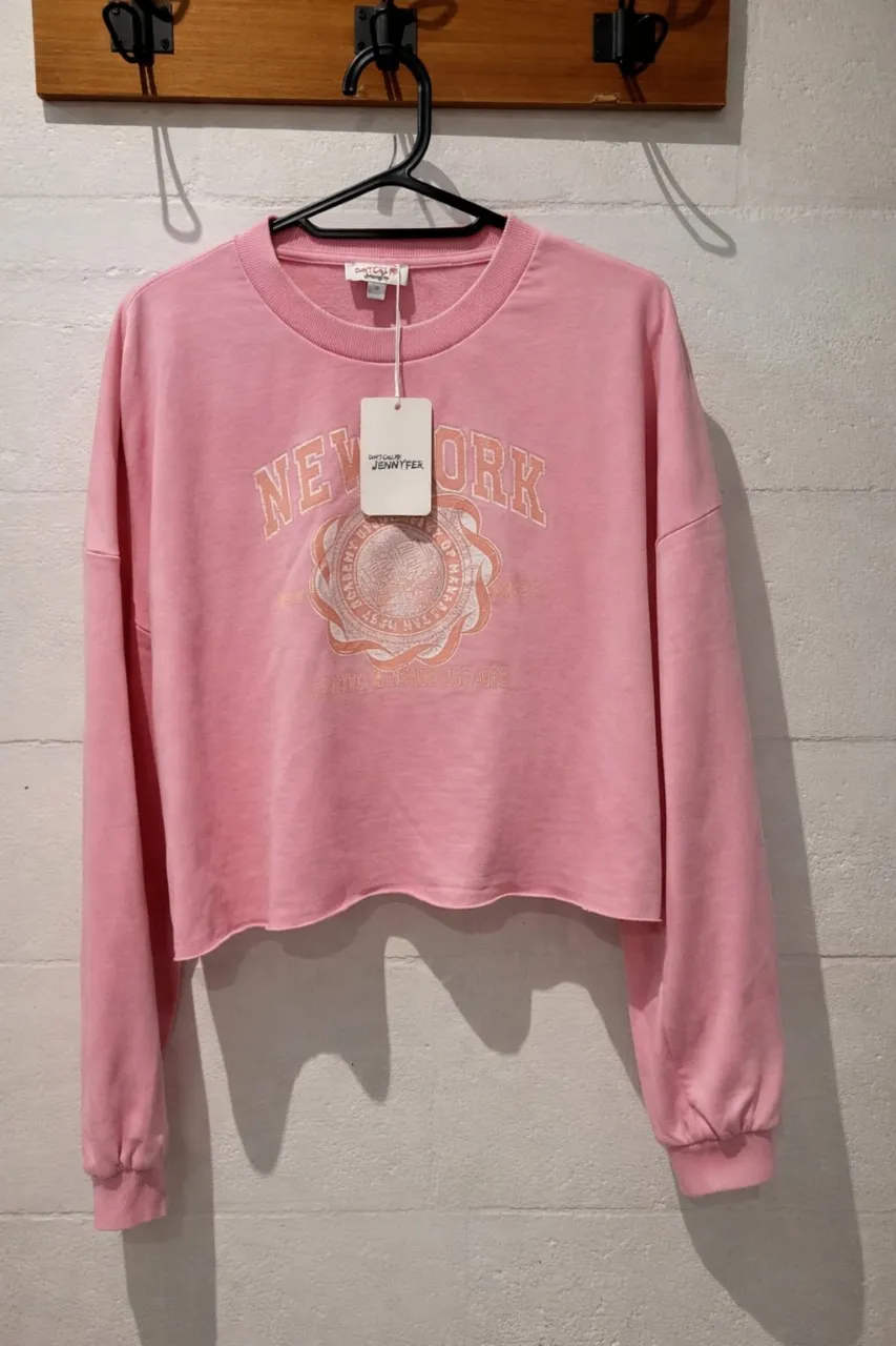 Remera manga larga color rosa con estampa "New York" en el frente. Cuello redondo y puños elastizados.