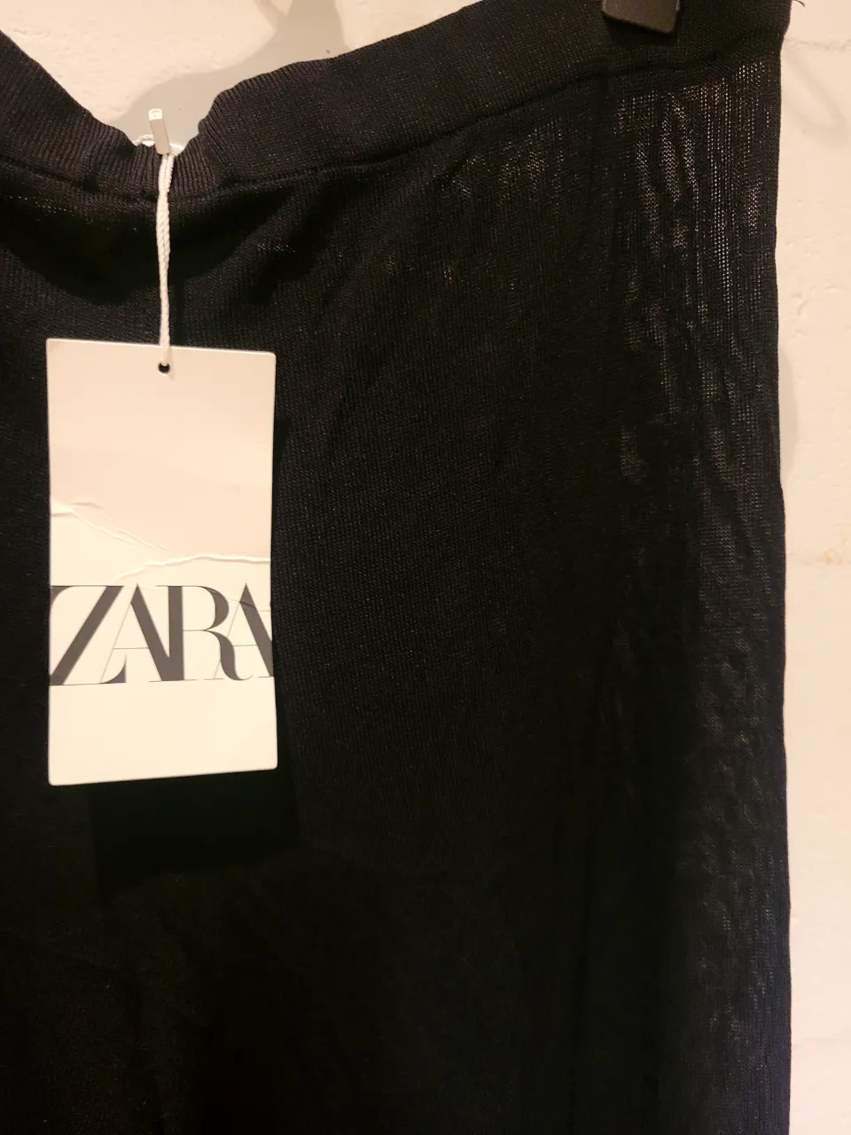 Pantalón semitransparente negro de Zara, tiro alto, con un corte ancho y tela liviana. Ideal para un look casual o elegante.