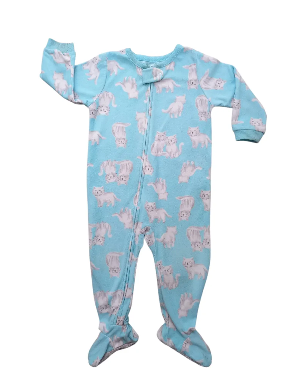 Enterito de bebé celeste con estampa de gatitos blancos y grises. Tiene cierre al frente y pies incorporados.