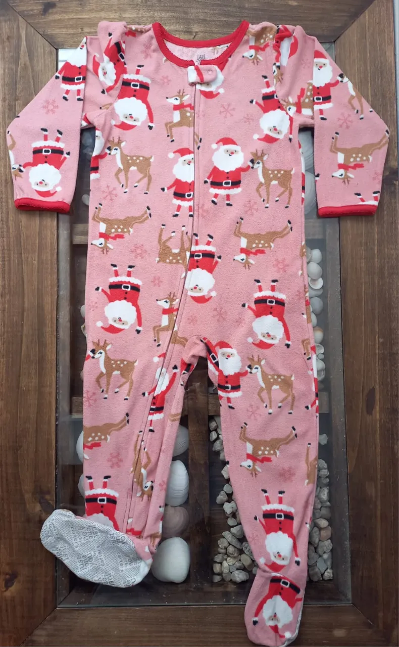 Enterito de bebé rosa con estampa de Papá Noel y renos. Tiene puños y cuello rojos. Los pies son antideslizantes.