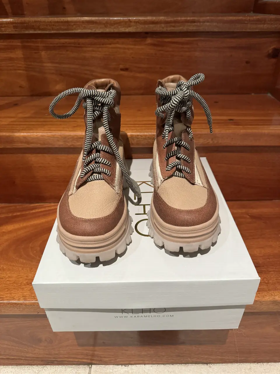 Botas de cuero de mujer color marrón y blanco, con cordones y suela gruesa. Ideales para un look casual y moderno.