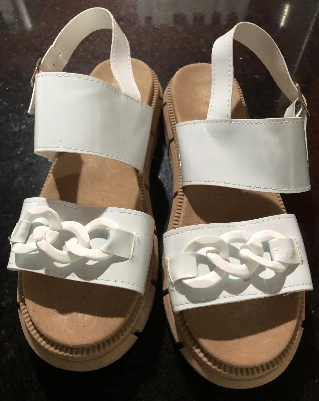 Sandalias blancas con detalles de cadena, ideales para un look fresco y moderno. Perfectas para el verano.