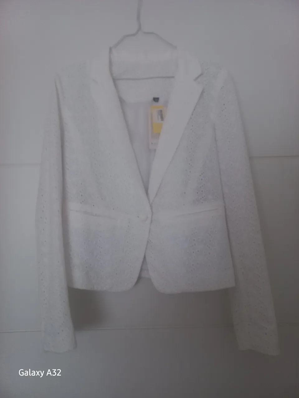 Blazer blanco con detalles calados, ideal para un look elegante y fresco. Perfecto para combinar con diferentes outfits.